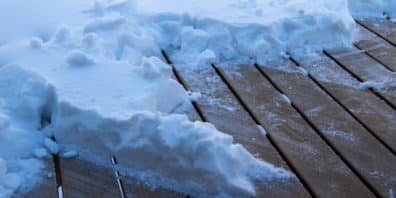 Pile of half-shoveled snow on a wooden deck