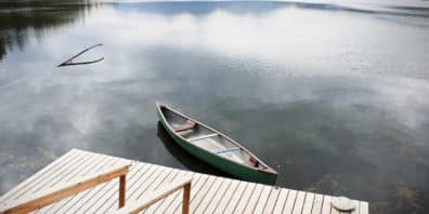 Kayak tied to a wooden dock on still water.